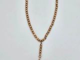 a close up of a gold chain with a coin on it