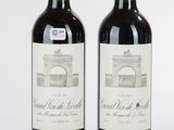 deux bouteilles de vin rouge posées l'une à côté de l'autre sur une surface blanche