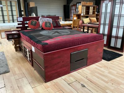 un lit en bois recouvert d'un revêtement noir et rouge