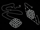 two pieces of silver jewelry are shown on a black background