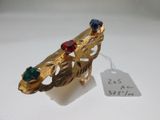 une image représentant une bague en or sertie de pierres bleues et rouges