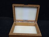 an open wooden box sitting on top of a black surface