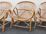 trois chaises en osier placées les unes à côté des autres sur un sol recouvert de moquette
