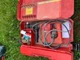 une boîte à outils rouge contenant un tuyau et d'autres objets