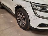 the front end of a white suv parked in a garage