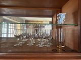 a glass shelf with wine glasses on it and a pair of scissors