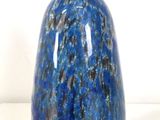 a blue vase that is sitting on a white surface
