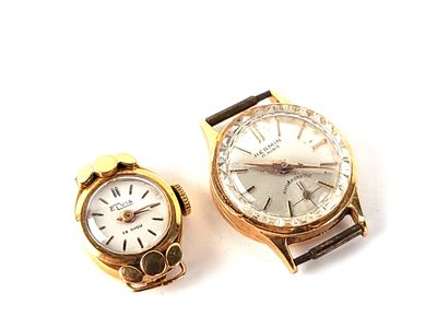 two watches sitting next to each other on a white surface