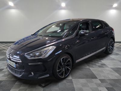 a black car is parked on a checkered floor in a garage