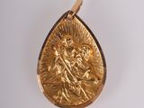 une photo d'un pendentif en or sur lequel figure une image de Jésus