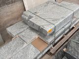 de nombreux blocs de granit posés sur une palette dans un entrepôt