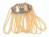 une photo d'une broche en or et diamants ornée de perles