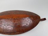 a wooden bowl with carvings on it on a white surface