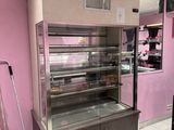 a display case in the middle of a room with pink walls