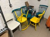 yellow and blue chairs and a table in a room with a white brick wall
