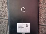 the back of a black tablet computer sitting on top of a tiled floor
