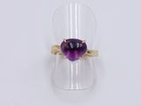 a close up of a ring with a purple stone in it