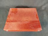 an orange alligator skin box on a black background