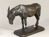 bronze statue of a donkey on a base with a tag on it ' s nose