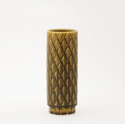 un vase marron orné d'un motif sur un fond blanc