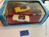 une boîte contenant deux petites voitures, posée sur une table
