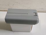 a small white box with a gray lid on a table