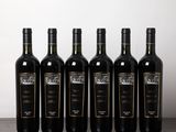six bouteilles de vin sont alignées sur une table en bois