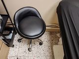 a black chair sitting in a room next to a bed