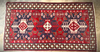 a red and blue rug with a pattern on it