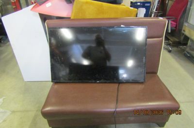 un téléviseur posé sur un canapé dans une pièce