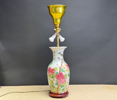 une lampe posée sur une table sur laquelle se trouve un vase