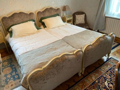 deux lits dans une chambre avec un tapis au sol