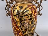 a gold and red vase with a dragon on it