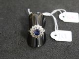 une bague en argent sertie d'une pierre bleue et sur laquelle est accrochée une étiquette de prix