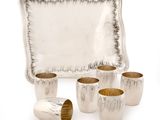 quatre tasses et un plateau sur lequel est posé un plateau en argent