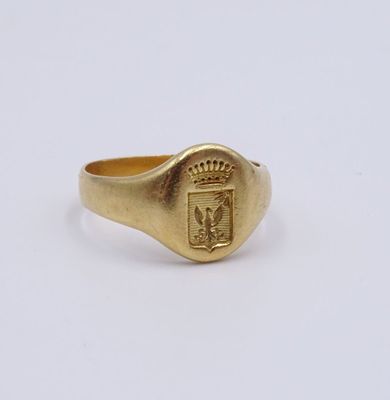 un gros plan d'une bague en or ornée d'un blason