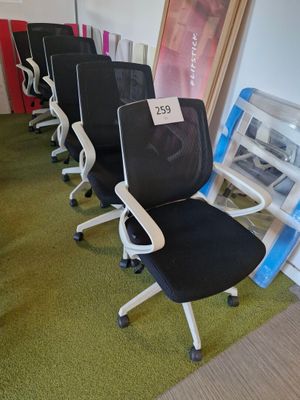 Plusieurs chaises de bureau sont alignées en rang dans une pièce