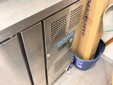 stainless steel counter top in a commercial kitchen next to a trash can