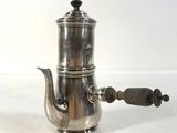 a silver coffee pot with a wooden handle on a white surface