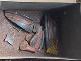 une boîte remplie de vieilles planches de skate posée par terre