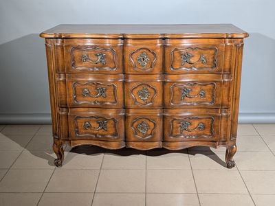 une commode en bois posée sur un sol carrelé