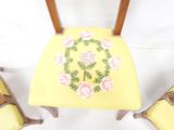 a yellow chair with a floral design on the back