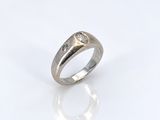 gros plan d'une bague en argent sur une surface blanche