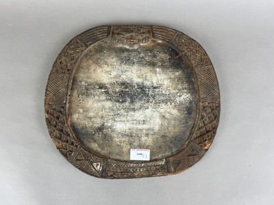 une plaque d'argent ornée d'un motif sur une surface blanche