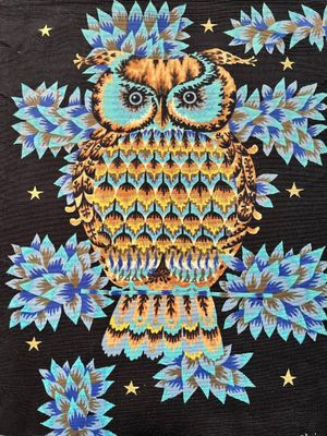 un hibou perché sur une branche d'arbre, entouré de fleurs bleues