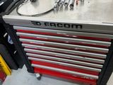une boîte à outils posée dans un garage, avec des outils dessus