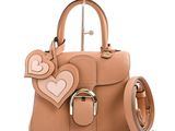 beige leather handbag with heart shaped handles and a metal handle