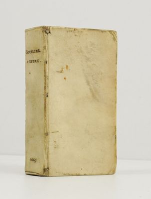 un vieux livre posé sur une table blanche à côté d'un mur blanc