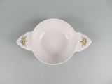 a white bowl with flowers on it on a table