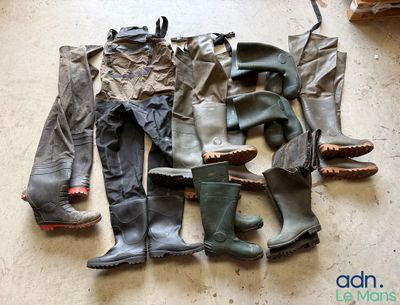 de nombreuses paires de bottes et de pantalons étalées par terre